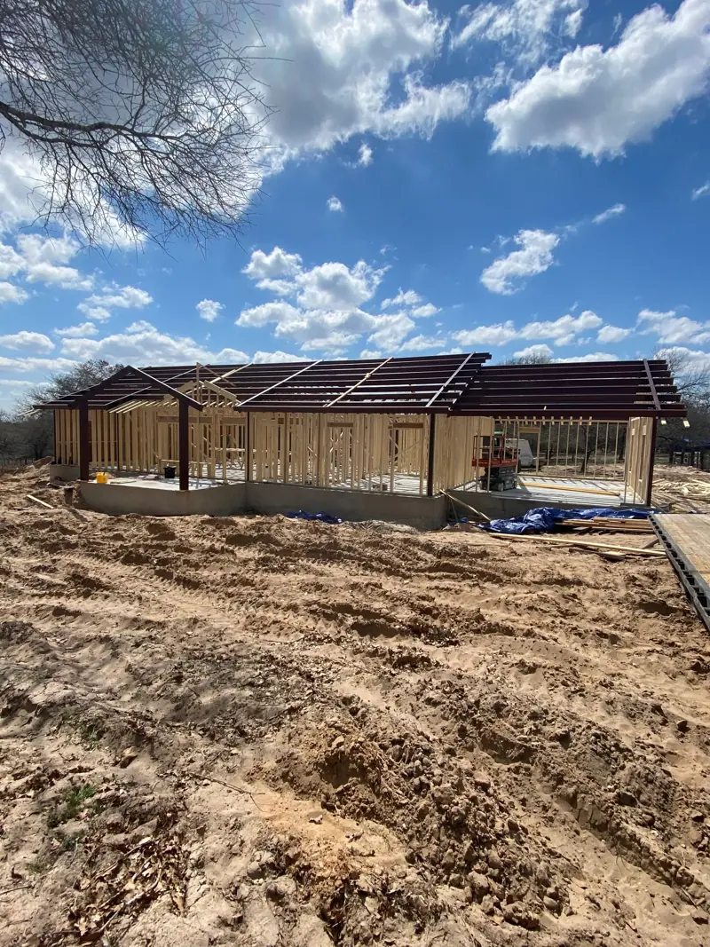 The building from the yard: steel roof frame over framed wood walls.