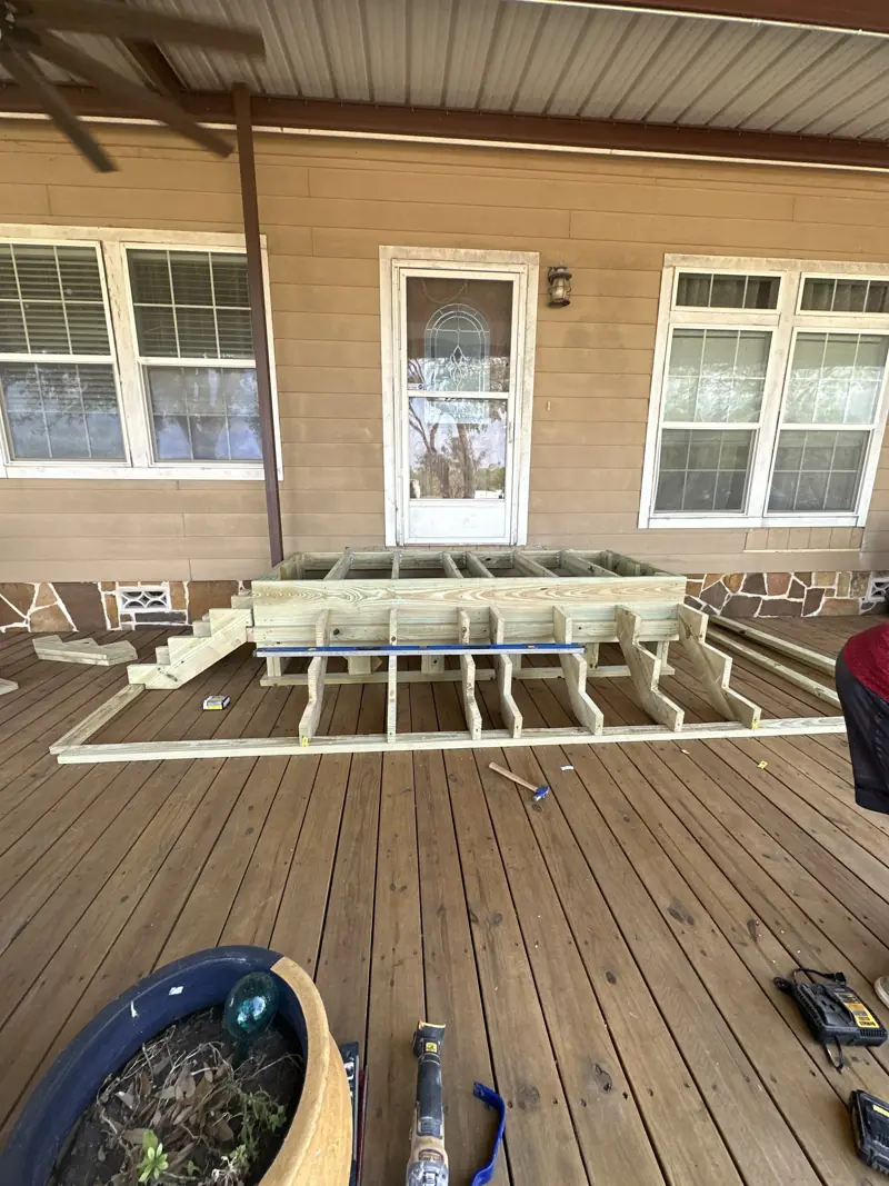 Treated lumber framing for wide steps on a wood porch deck.