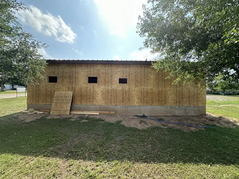 Side wall in OSB sheathing with small window openings.