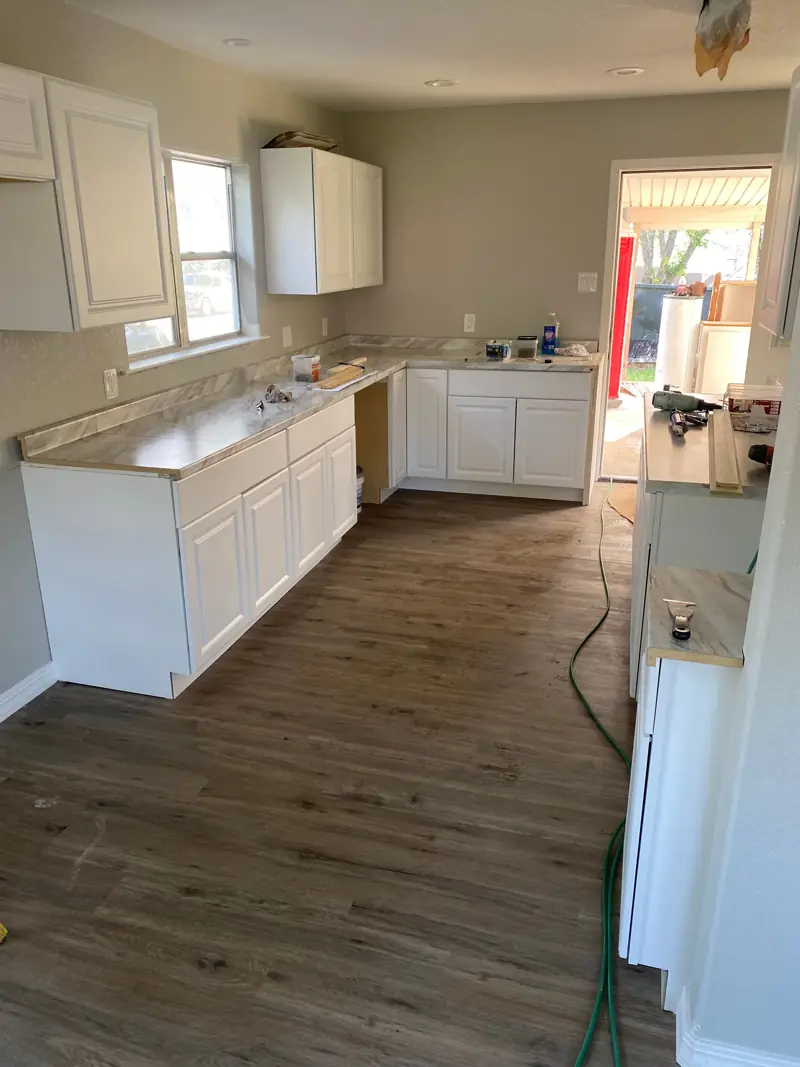 Kitchen with new white cabinets and counters on.