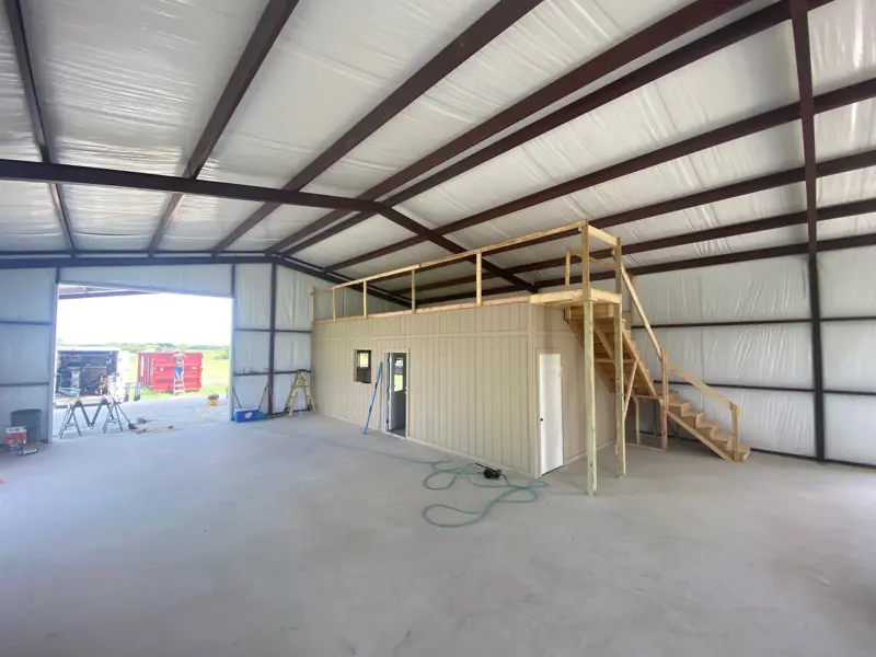 Finished shop office with a loft deck on top and stairs up the side.