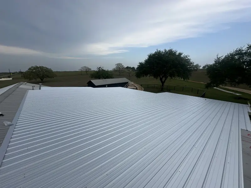 New ribbed metal roof panels over the patio, tying into the existing metal roof of the house.