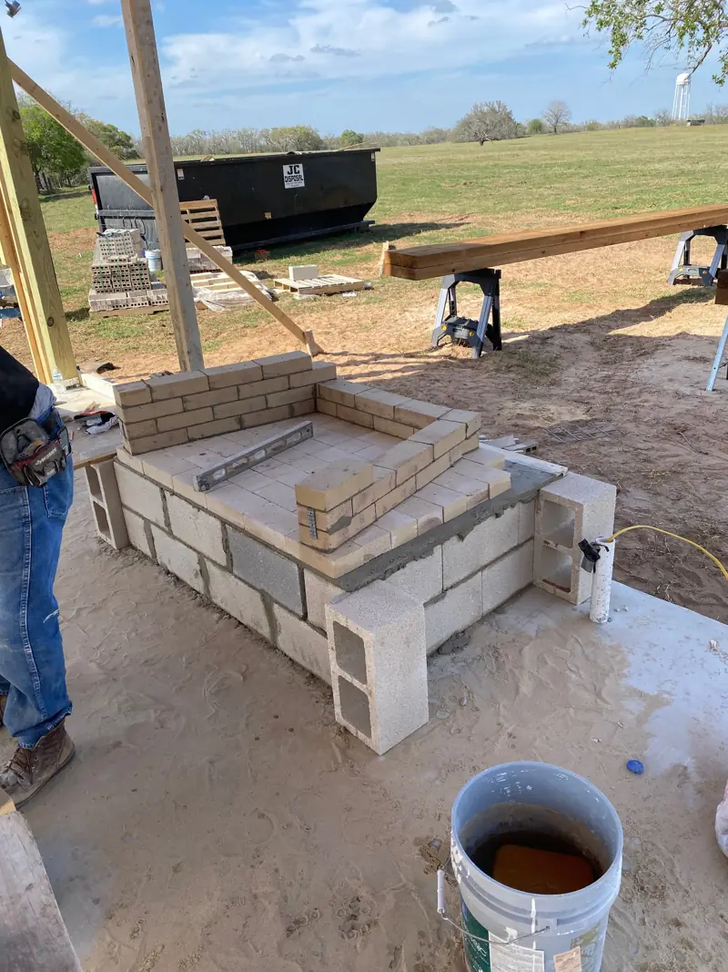 Base of the fireplace in concrete block, with firebrick for the firebox.