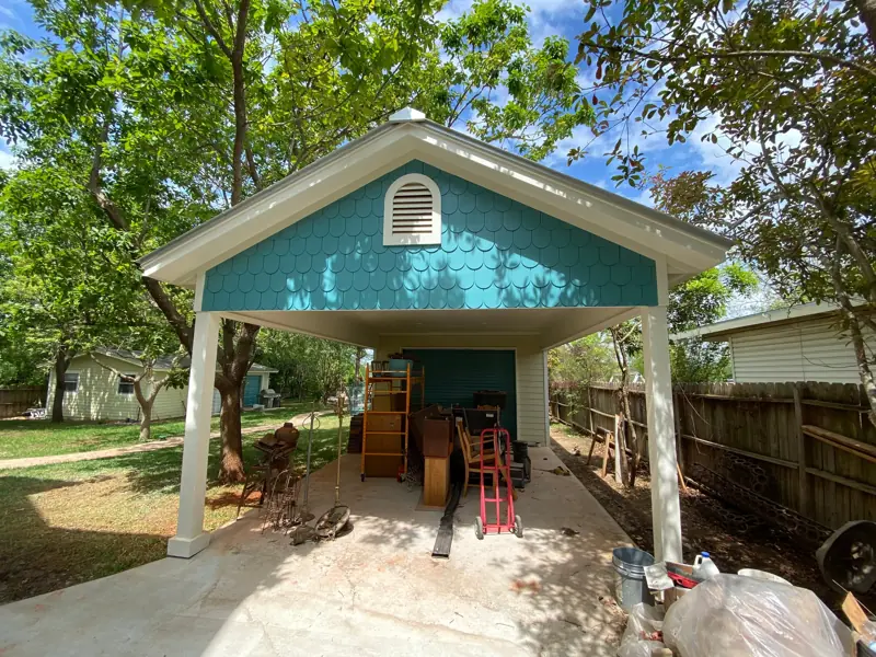 New carport with a teal fish-scale shingle gable.