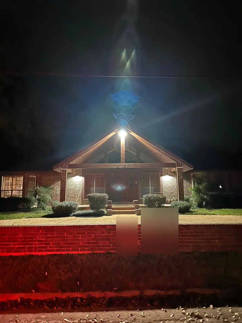 The porch gable lit at night.