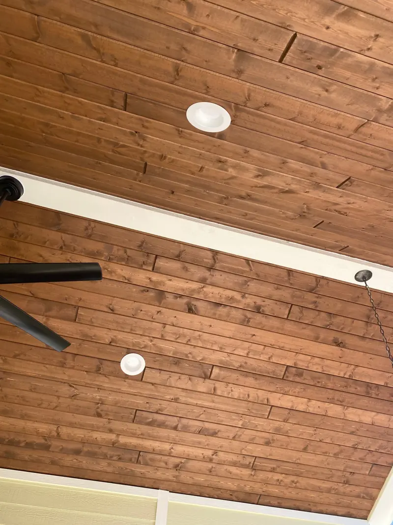 Stained wood porch soffit with recessed lights.