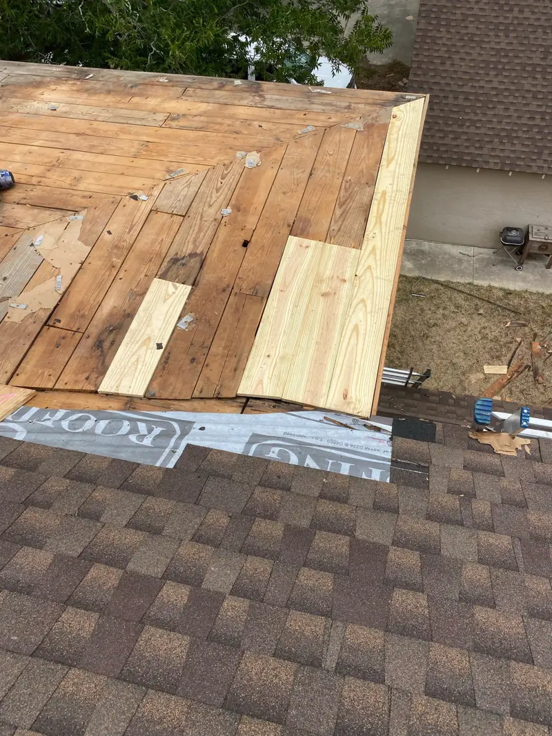 New boards at the roof edge beside the old decking.