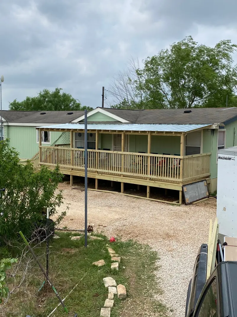 Covered deck with a metal roof, seen from the yard.
