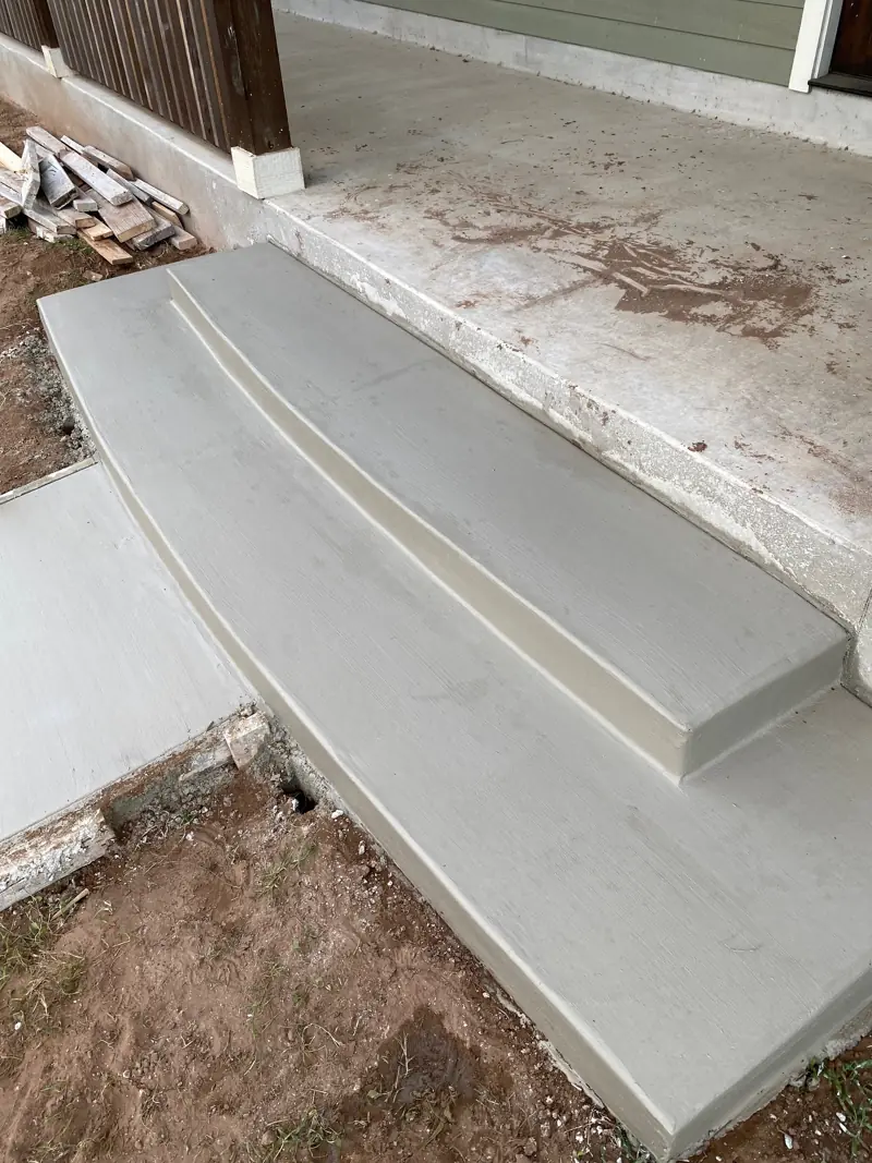 New concrete steps at the edge of a porch.