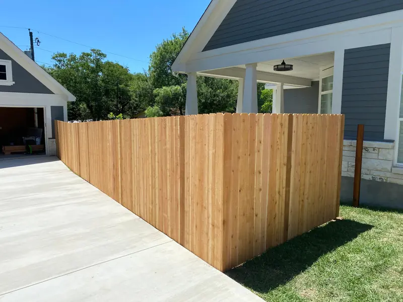 New cedar privacy fence beside the garage and the driveway.
