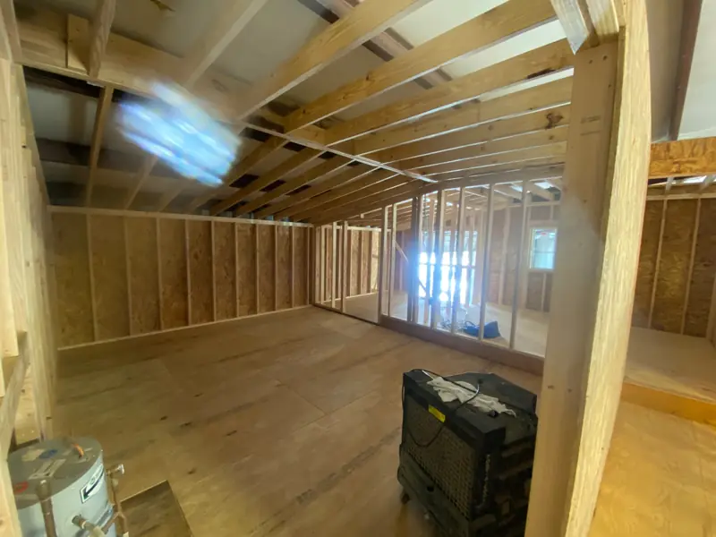 Upper floor framed with a plywood floor and stud walls.