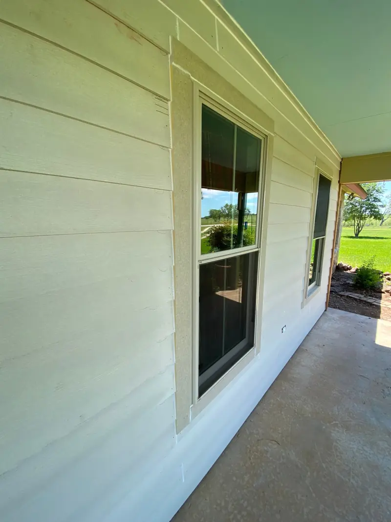Finished white siding along the porch and windows.